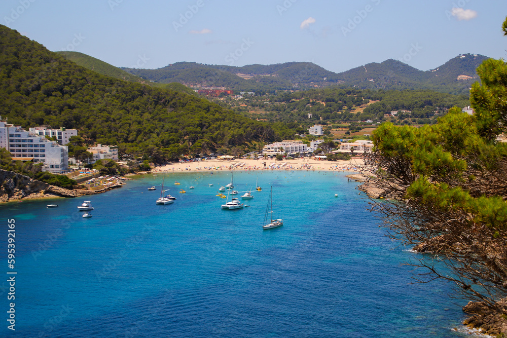 Cala Llonga bay on the southern side of Ibiza in the Balearic islands in the Mediterranean Sea - Cove with turquoise waters surrounded with pine covered hills Cala Llonga bay on the southern side of Ibiza in the Balearic islands in the Mediterranean Sea - Cove with turquoise waters surrounded with pine covered hills