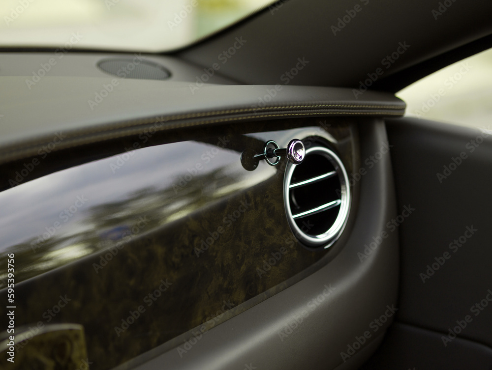 A close-up view of the interior modern luxury car with a view of the ventilation chrome round deflector of the stove for heating and cooling the passenger compartment with black trim
