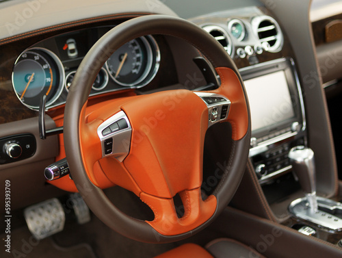 Modern luxury car Interior. orange leather steering wheel, shift lever and dashboard. Car interior luxury inside