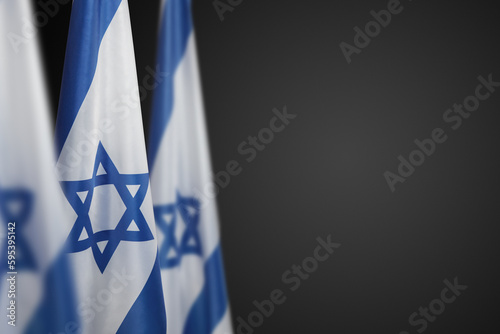 Israel flags with a star of David over dark gray background. Banner with place for text. photo