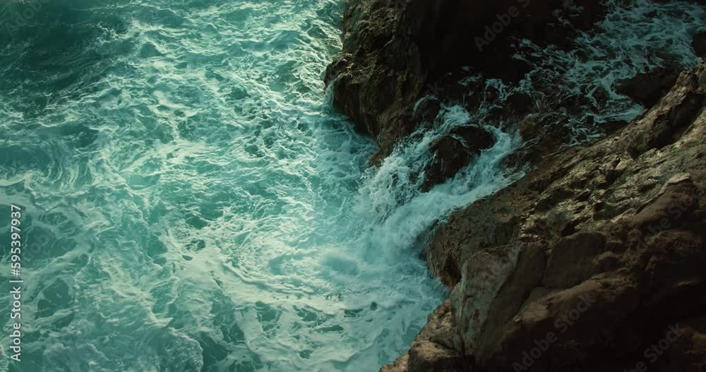 Waterfall flows through rocky gorge and mixes with ocean water. Powerful nature. Waterfall flows through rocky gorge and mixes with ocean water. Powerful nature.