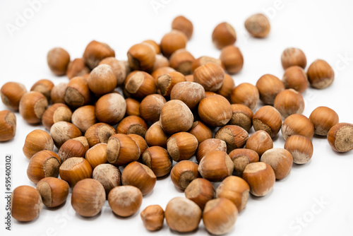 Pile of hazelnuts in a shell on white background