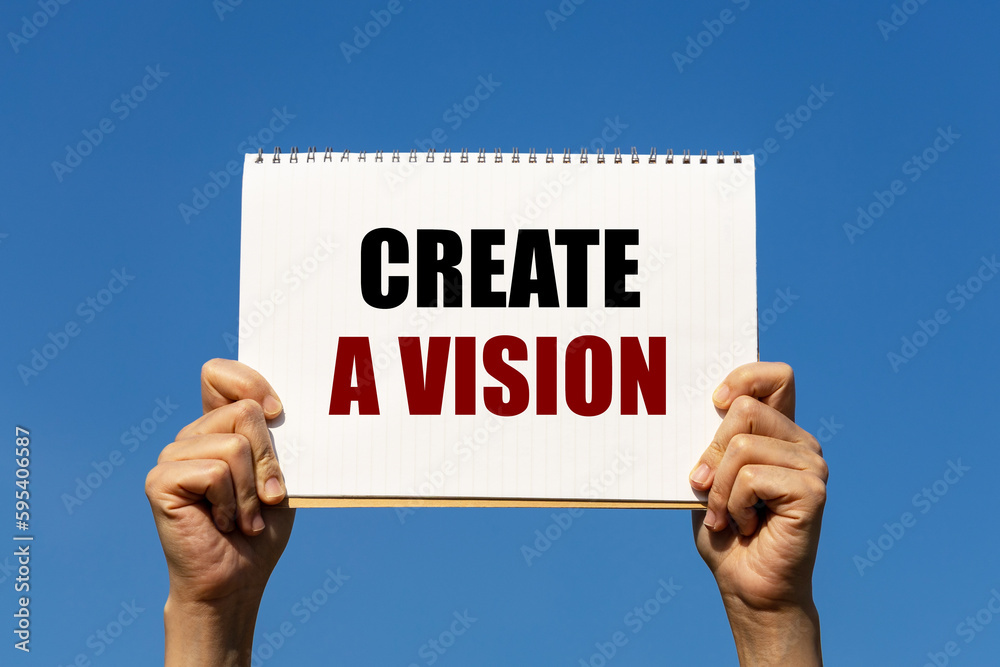 Create a vision text on notebook paper held by 2 hands with isolated blue sky background. This message can be used as business concept about vision. Create a vision text on notebook paper held by 2 hands with isolated blue sky background. This message can be used as business concept about vision.
