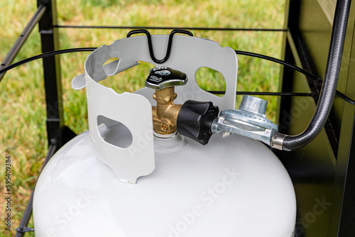 Propane gas cylinder with hose and regulator for BBQ grill. Grilling safety, LPG equipment inspection and storage photo