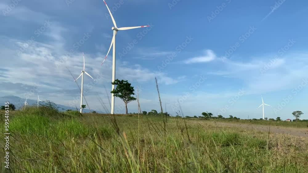 A wind turbine in a field with the sky in the background