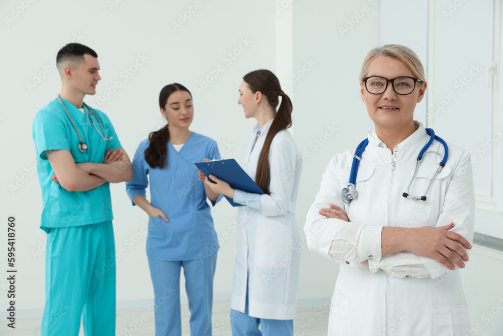 Portrait of doctor near colleagues in clinic Portrait of doctor near colleagues in clinic