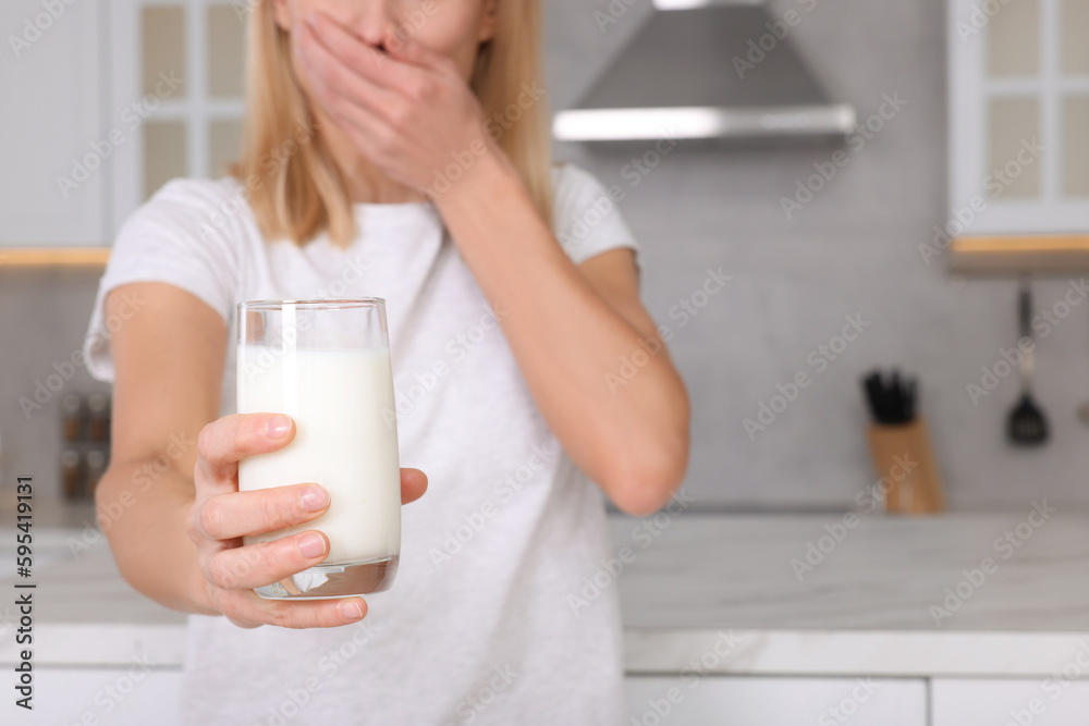 Woman with glass of milk suffering from lactose intolerance in kitchen, closeup. Space for text Woman with glass of milk suffering from lactose intolerance in kitchen, closeup. Space for text