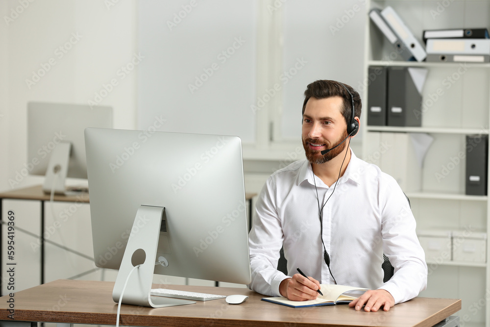 Fototapeta premium Hotline operator with headset working in office