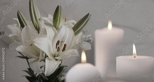 Funeral. White lilies and burning candles on light grey background, banner design