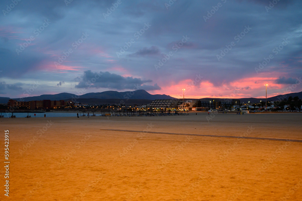 Sandy beach after sunset. Winter vacation in sunny Caleta de Fuste touristic village on Fuerteventura, Canary islands, Spain
