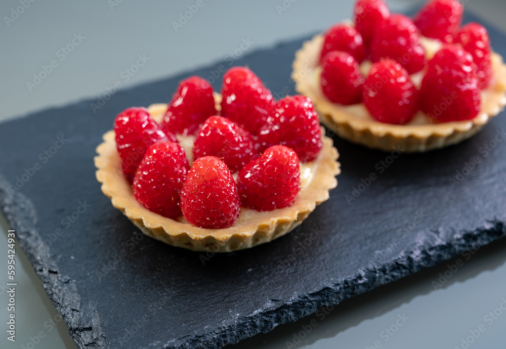 Artisanal baked small tart with cream and fresh ripe red raspberry Artisanal baked small tart with cream and fresh ripe red raspberry