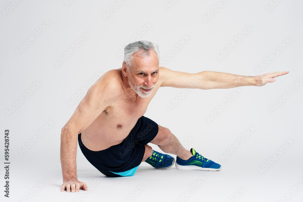 Handsome elderly man doing push ups isolated on white background. Senior man training his body Handsome elderly man doing push ups isolated on white background. Senior man training his body