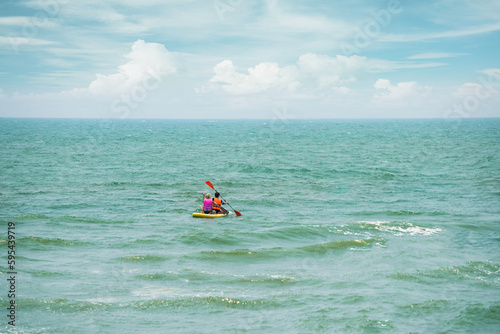 Kayaking in the sea from back view . women canoeing in turquoise sea.