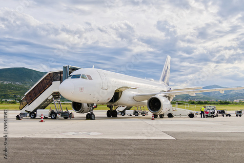 Aircraft parking at the airport. The plane is being prepared for departure by airport staff.