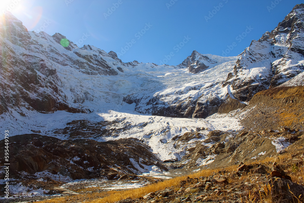 Mountain glaciers and large blocks of snow with ice in the eternal glaciers in Alibek, Dombay, Karachay-Cherkess Rep. Russia, Blue sky with copy space for text