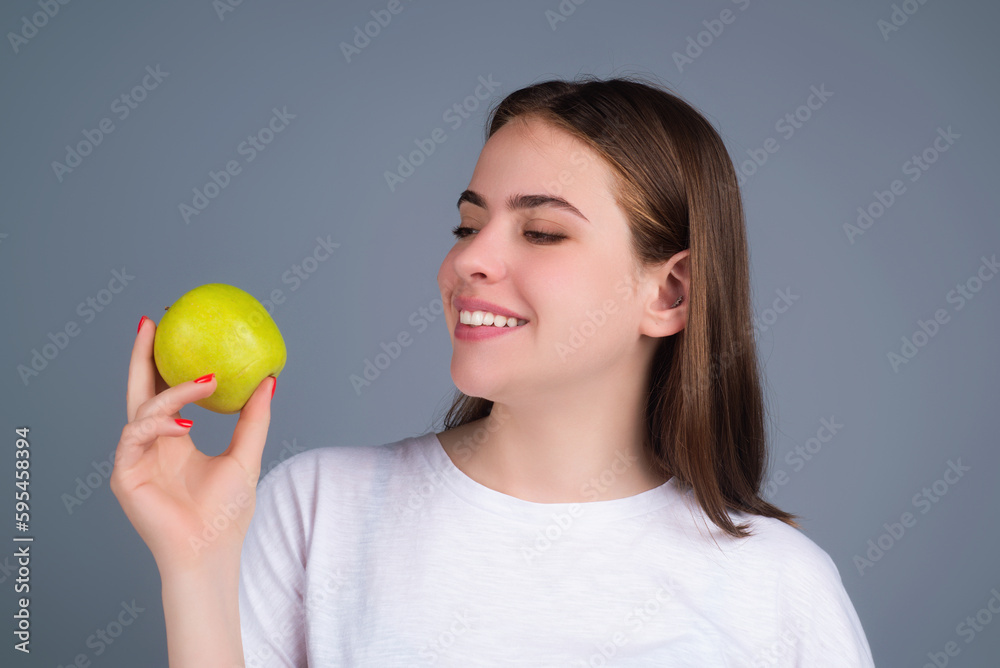 Woman bitting tasty apple. Woman eating apple, studio portrait. Morning breakfast. Woman with healthy teeth holding apples on isolated background. Woman holding apple. Woman bitting tasty apple. Woman eating apple, studio portrait. Morning breakfast. Woman with healthy teeth holding apples on isolated background. Woman holding apple.