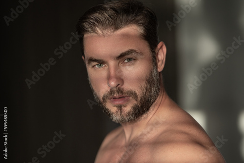 Closeup portrait of attractive man for cream on male face cosmetics advertising. Beautiful man close up portrait on white background. Naked shoulders, skin care, health, cosmetics for skin.