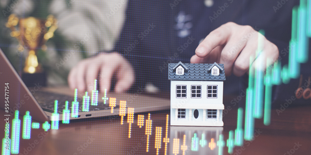 The concept of buying and selling real estate. A man with a model of a house on the background of the forex chart. - obrazy, fototapety, plakaty 
