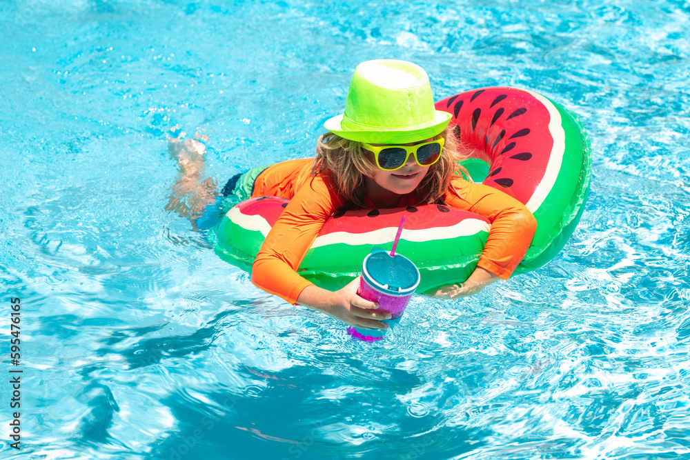 Happy kid playing with colorful swim ring in swimming pool on summer day. Child water vacation. Children play in tropical resort. Summer swimming and relax, swim on ring in pool, poolside.