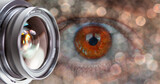 Camera lens glass with beautiful hazel girl eye and blue bokeh 