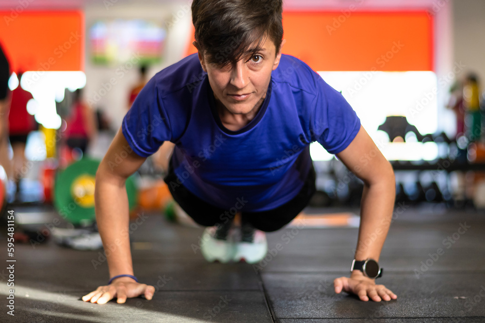 Fitness Woman In The Gym.
Concentrated caucasian woman wearing sports clothes working out in the gym doing plank position. Fitness Woman In The Gym.
Concentrated caucasian woman wearing sports clothes working out in the gym doing plank position.