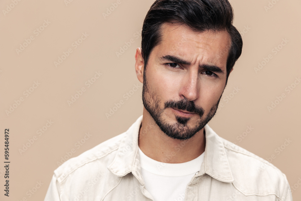 Portrait of a stylish man dissatisfied and angry screaming on a beige background in a white t-shirt looking at the camera, fashionable clothing style, copy space, space for text Portrait of a stylish man dissatisfied and angry screaming on a beige background in a white t-shirt looking at the camera, fashionable clothing style, copy space, space for text
