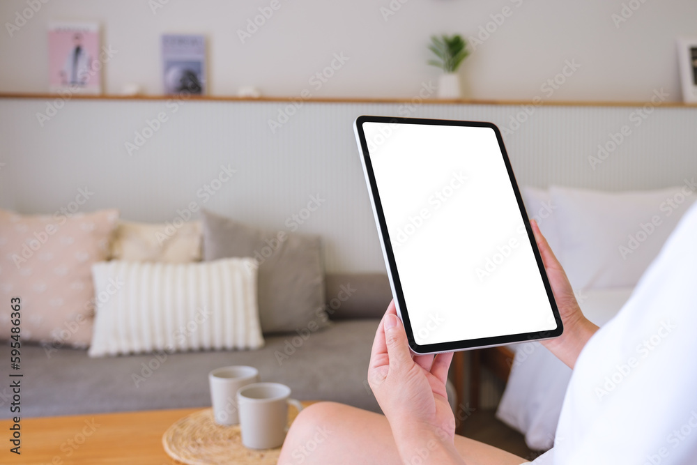Mockup image of a woman holding digital tablet with blank desktop screen at home Mockup image of a woman holding digital tablet with blank desktop screen at home