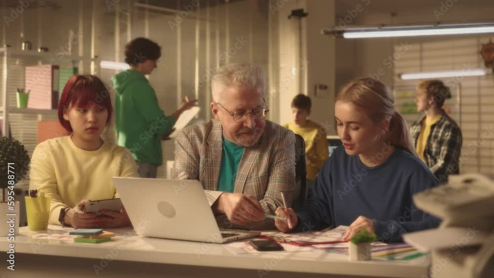 An elderly man makes comments to female managers about errors in the report and gets angry. European and Asian office workers sit at the table. An elderly man makes comments to female managers about errors in the report and gets angry. European and Asian office workers sit at the table.