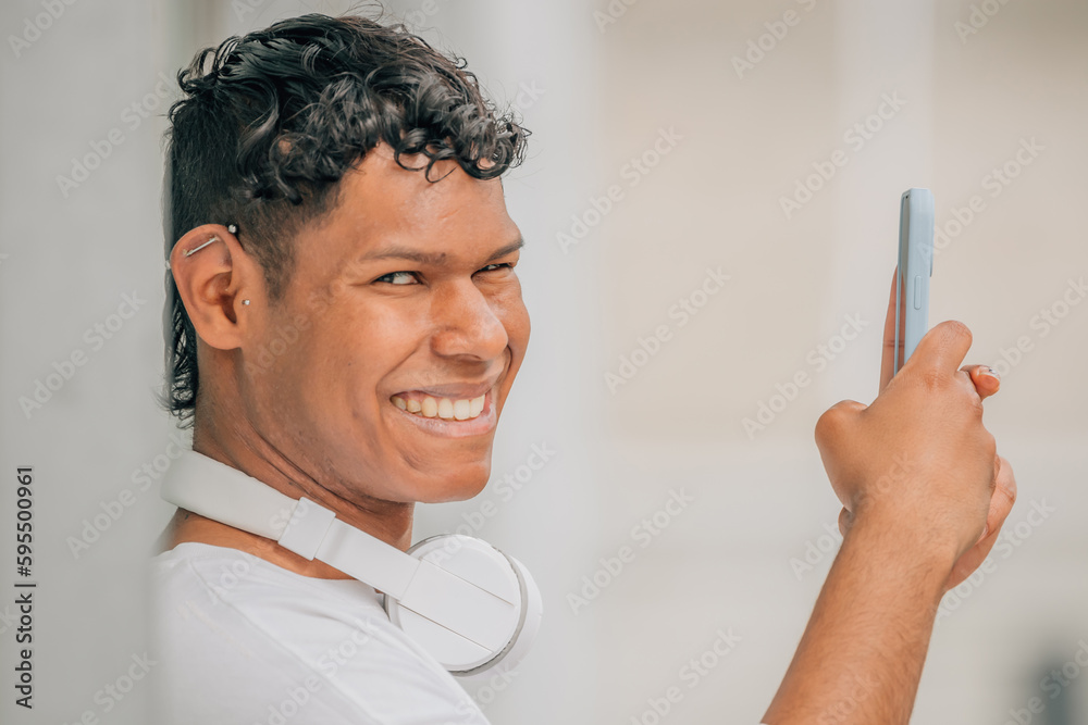 young latino male in the street looking at the mobile phone young latino male in the street looking at the mobile phone
