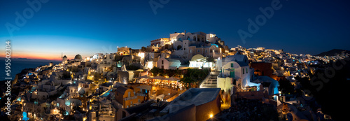 Panoramic view of Oia Coastal Town, Tholos, Santorini in Greece during the blue hour. 