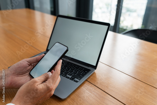 Man hands with smartphone and laptop with blank screens