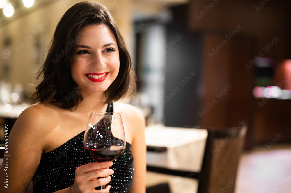 Beautiful woman holding a glass of red wine Stock Photo | Adobe Stock