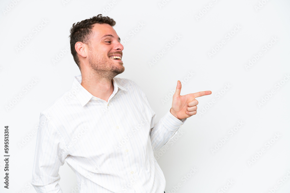 Young caucasian handsome man isolated on white background pointing finger to the side and presenting a product