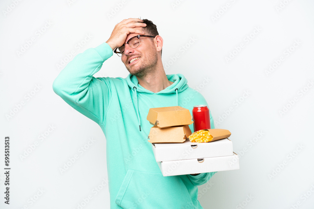 Young caucasian man holding fast food isolated on white background has realized something and intending the solution Young caucasian man holding fast food isolated on white background has realized something and intending the solution