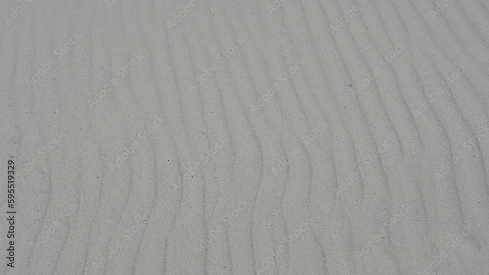 White sand dune with ripples and wisps of sand being blown off the crest. White sand dune with ripples and wisps of sand being blown off the crest.