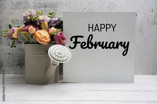 Happy February text message with flower bouquet on wooden background