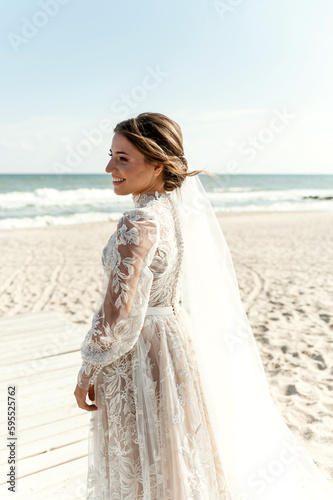 happy bride is on the beach waiting to meet her groom. portrait of a cute bride with a bouquet of wild flowers. wedding day