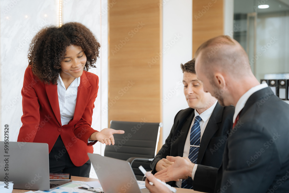 Mature business leader consultant talking to team of diverse colleagues listening to white CEO. Group project manager negotiating in the boardroom at a meeting. Mature business leader consultant talking to team of diverse colleagues listening to white CEO. Group project manager negotiating in the boardroom at a meeting.