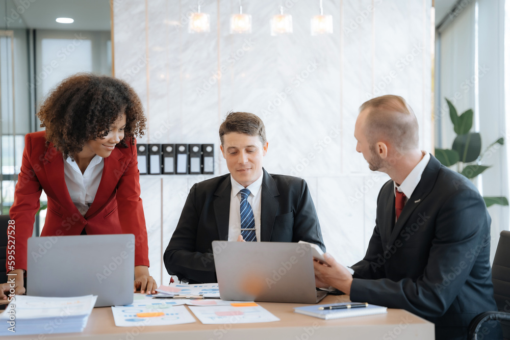 Mature business leader consultant talking to team of diverse colleagues listening to white CEO. Group project manager negotiating in the boardroom at a meeting. Mature business leader consultant talking to team of diverse colleagues listening to white CEO. Group project manager negotiating in the boardroom at a meeting.