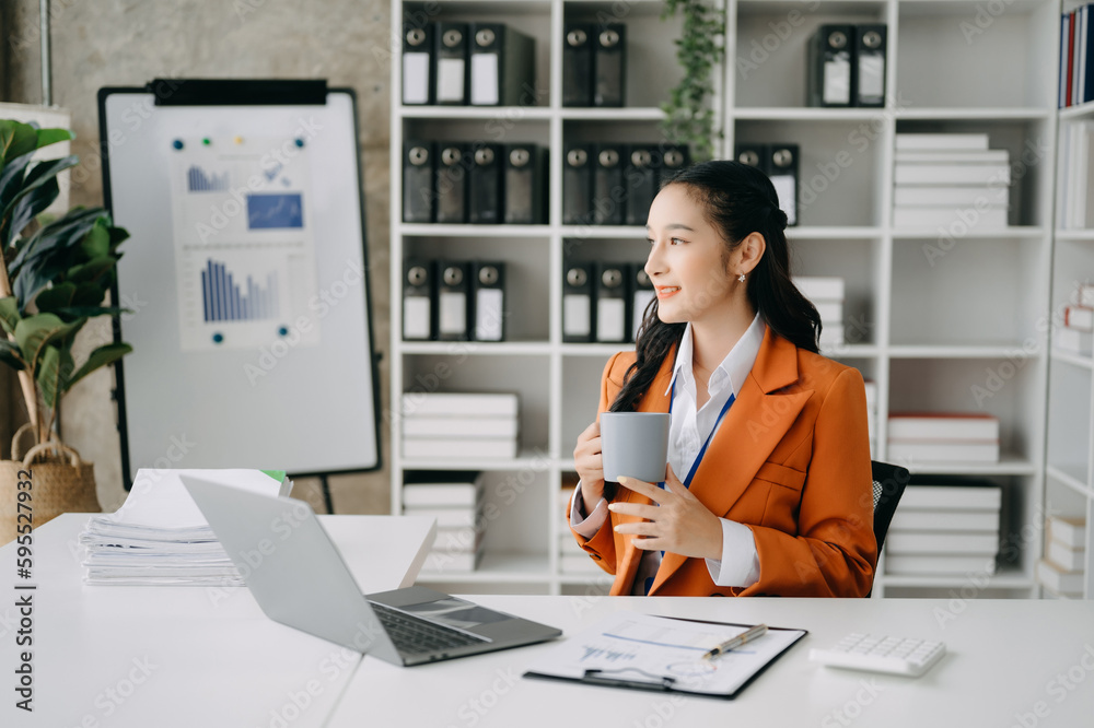 Business woman using tablet and laptop for doing math finance on an office desk, tax, report, accounting, statistics, and analytical research concept in office