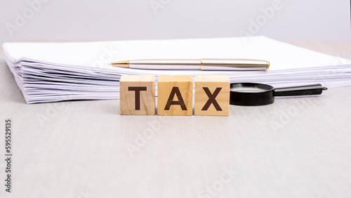 text TAX written on the wooden cubes in black letters, the cubes are located on a white surface