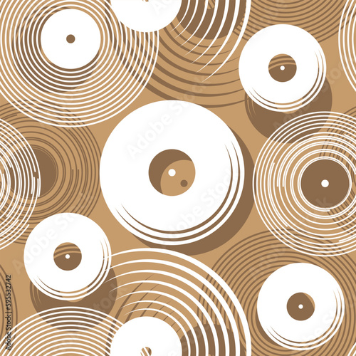 Seamless pattern with randomly arranged stylized images of vinyl records in white and dark brown. Light brown background. Vector illustration