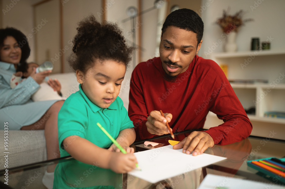 Selective focus on african father drawing with little daughter Selective focus on african father drawing with little daughter