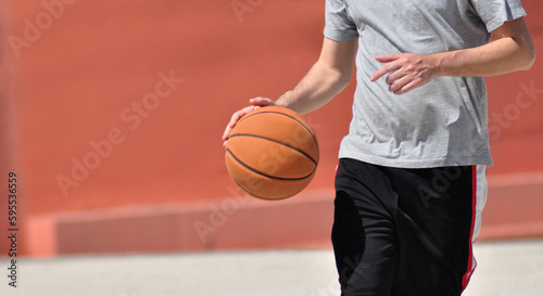 Basketball player with ball, male person playing outdoors space, dribbling the ball