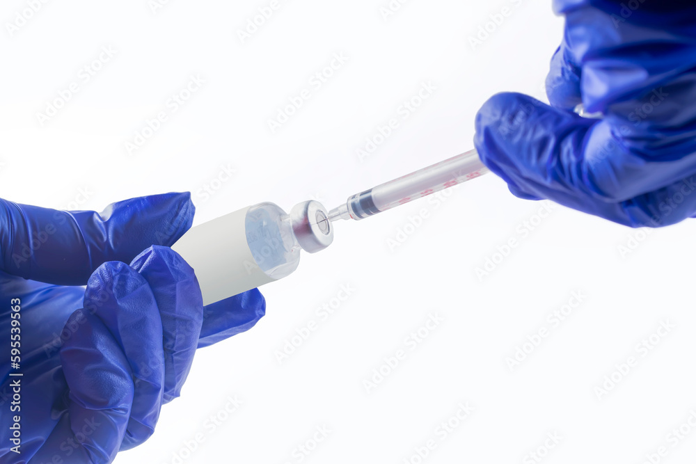 Vaccination concept. Doctor's hand in blue gloves hold medicine vaccine vial bottle and syringe. coronavirus vaccine. Health and medical concepts Vaccination concept. Doctor's hand in blue gloves hold medicine vaccine vial bottle and syringe. coronavirus vaccine. Health and medical concepts