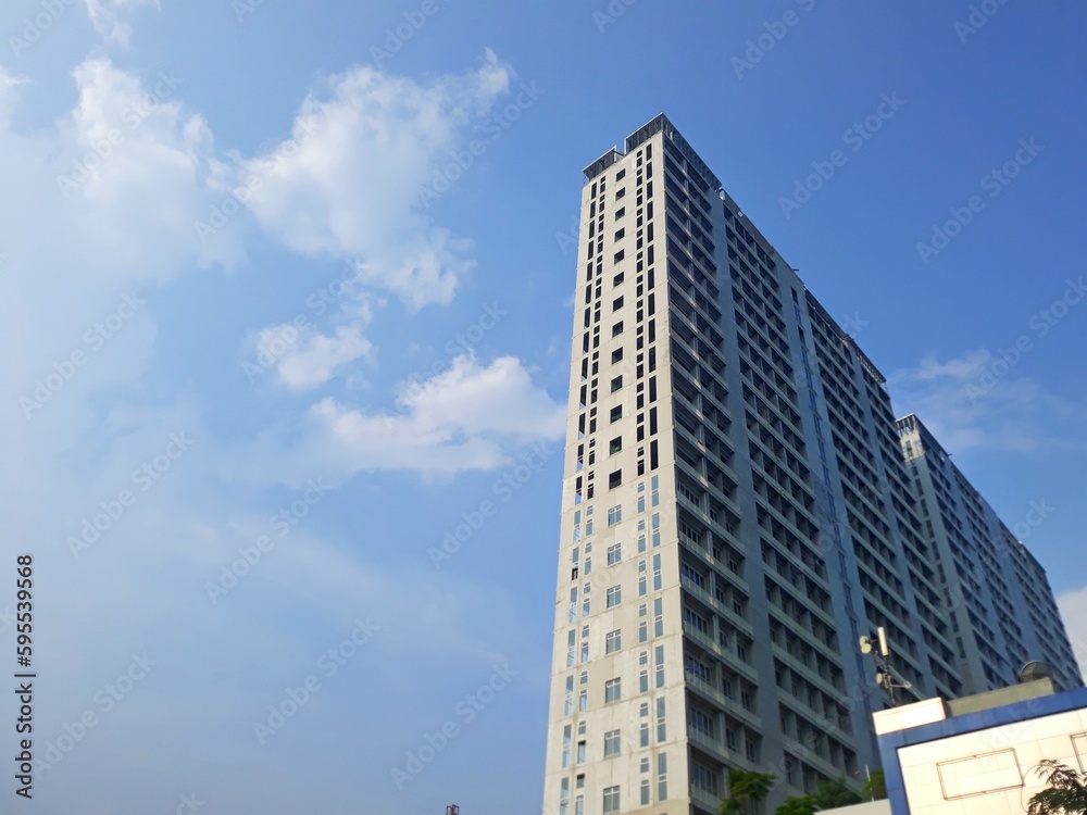 Low angle un finish high tower building with bright blue sky. Selective focus Low angle un finish high tower building with bright blue sky. Selective focus