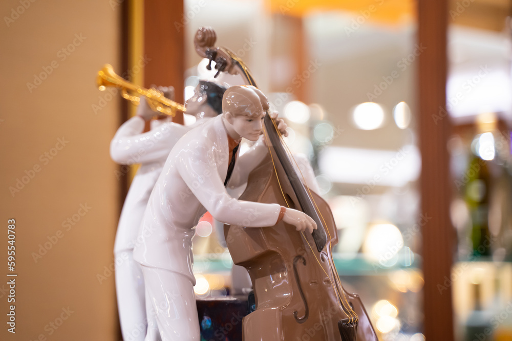 Male ceramic doll playing the violin. light effect background