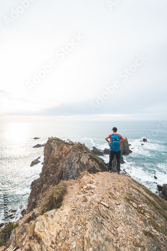 Backpacker rests during his journey along the Atlantic coast in western Portugal, along the famous Fisherman Trail. Resting at sunset