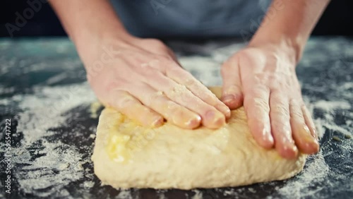 Close-up of a chef's hands shaping dough into a pizza pan. Cooking a delicious dinner with pastries at home. High quality 4k footage photo