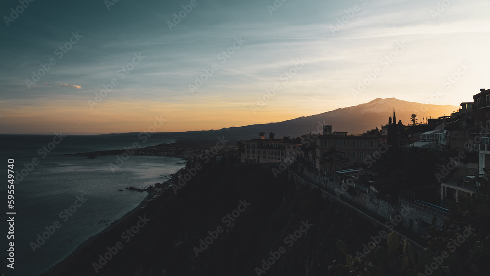 Panorama of the beach of Taormina, Sicily. Exciting sunset oversicilian sea seen from the terrace of the city, on the southern slopes of the Peloritani mountains, ionian coast, near Etna volcano.